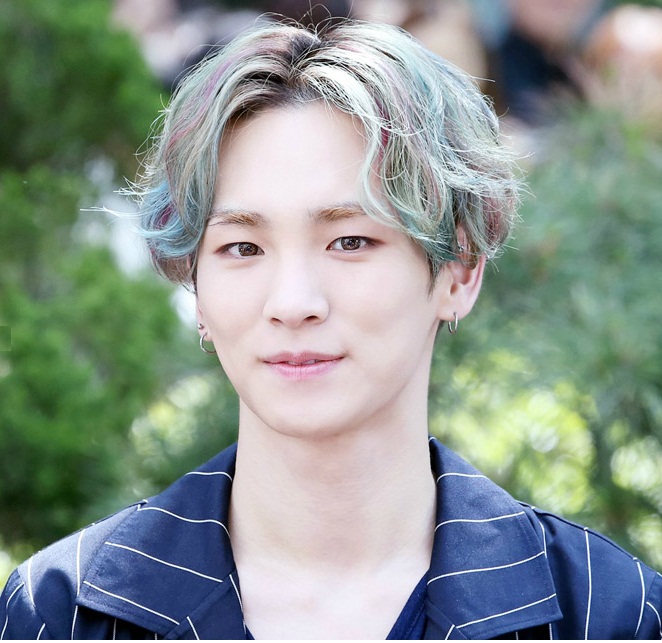Shinee Key trong kiểu tóc rẽ hai mái uốn xoăn nhuộm nâu highlight xanh