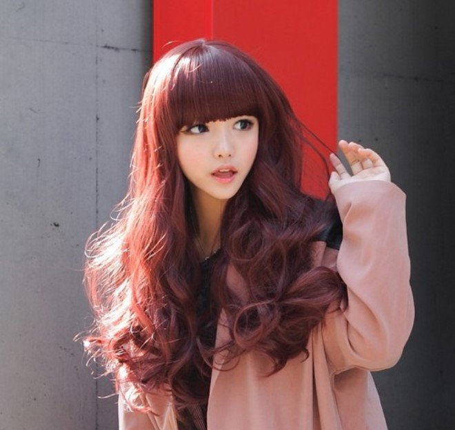 cô gái tóc dài uốn đuôi nhuộm màu nâu ánh đỏ