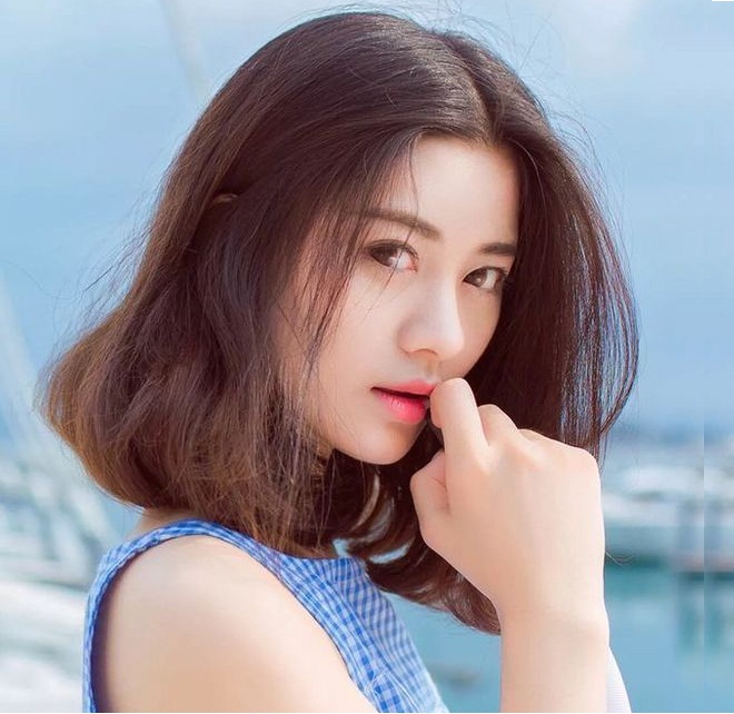 cô gái mặc áo xanh tóc cắt ngang vai uốn cụp đuôi